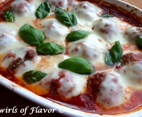 Baked Meatballs Parmesan, an easy homemade meatball recipe that's cheesy and saucy, will warm you up for dinner tonight! Just shape our homemade beef mixture into meatballs, smother with sauce and let them bake themselves in the oven.Â #meatballs #homemademeatballs #meatballsparmesan #easyrecipe #dinner #ovenbakedmeatballs #casserole #swirlsofflavor
