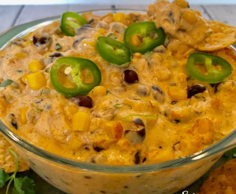 Creamy Corn and Black Bean Dip, an easy dip recipe that's bursting with cheesy goodness and a hint of spice, served with tortilla chips or fresh veggie dippers, is a delicious way to kick off your Cinco de Mayo fiesta! #easyrecipe #entertaining #hotdip #corn #blackbean #creamydip #appetizer #partyfood #gameday #swirlsofflavor
